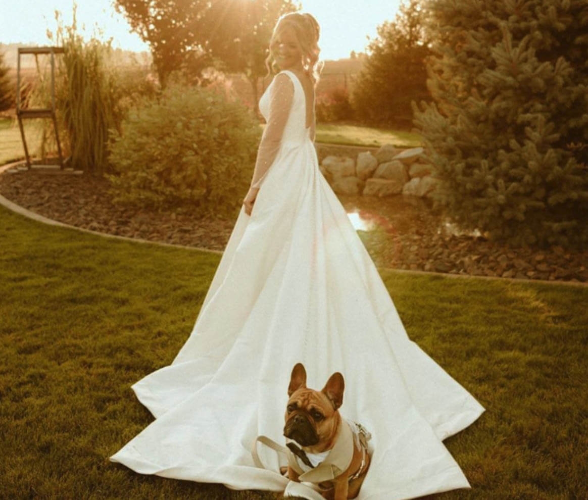 Model wearing a bridal gown with a dog